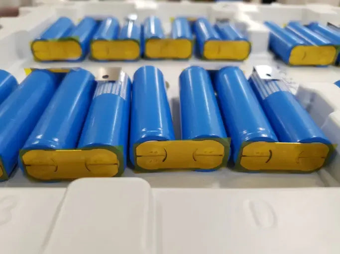 Cylindrical lithium batteries prepared for export with copper busbars — part of Wellgo Battery’s custom nickel-plated busbar manufacturing process for EV and energy storage systems.